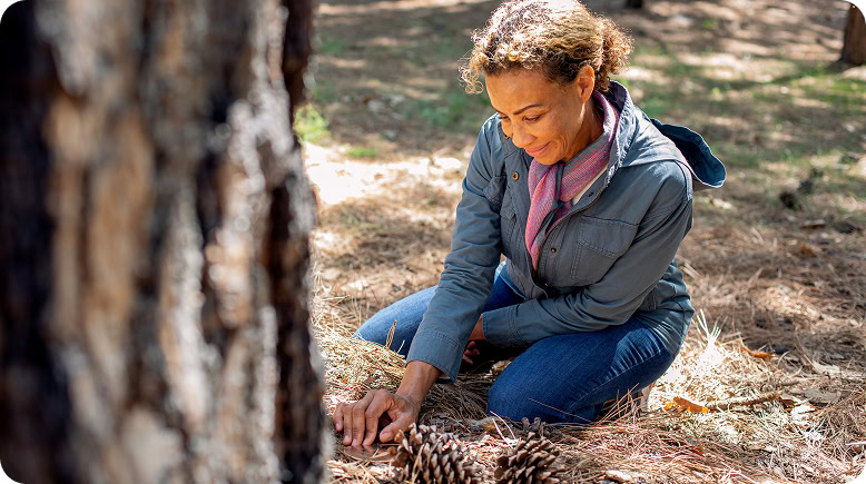 A woman honoring the cremated remains of a loved one at a memorial tree