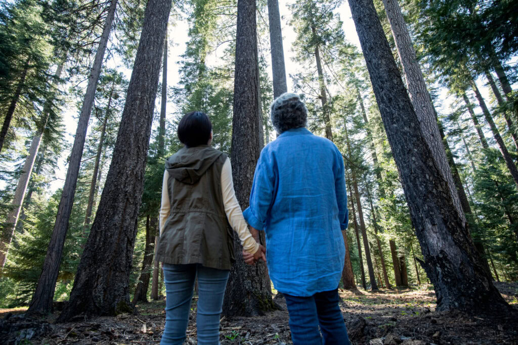 A woman stands with her mom to show how she is caring for someone with dementia