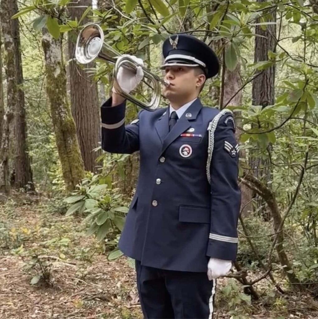 A photo of Taps being played at a Forest Memorial for a veteran.