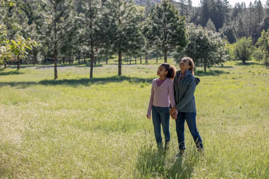 a mom and daughter stand in a meadow. Thinking about the end-of-life options in California