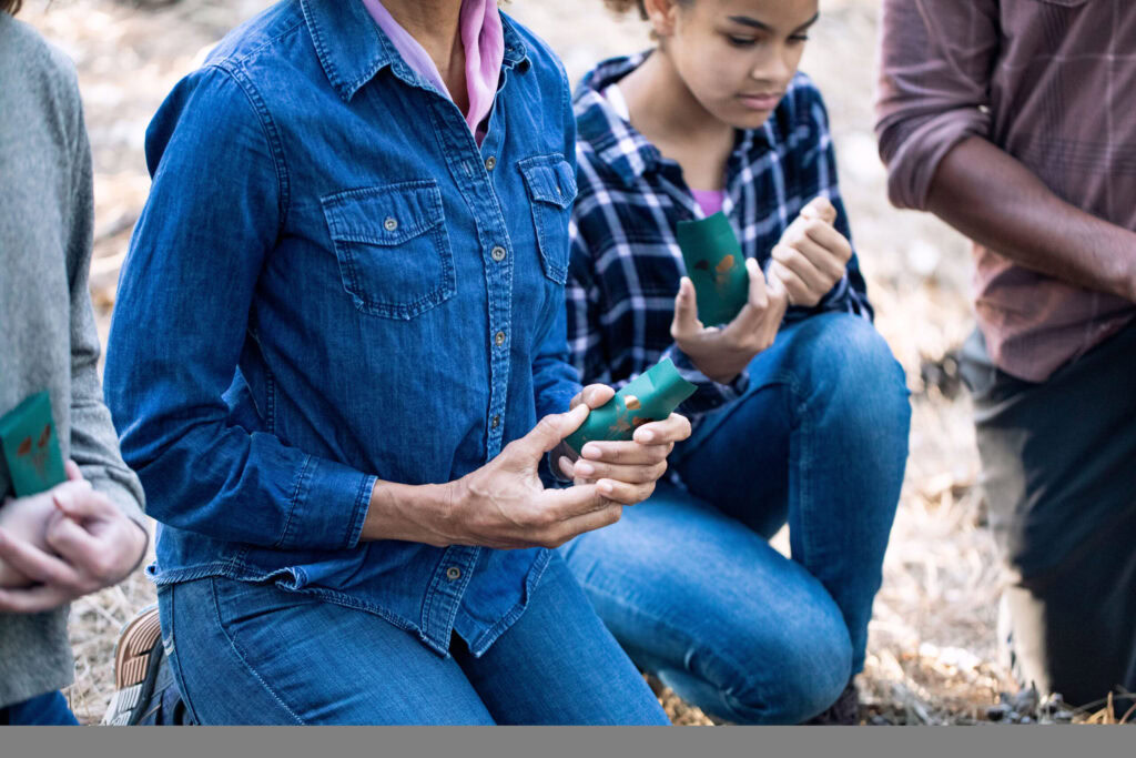 a woman kneels with wildflower seeds. She is thinking about debt when you die