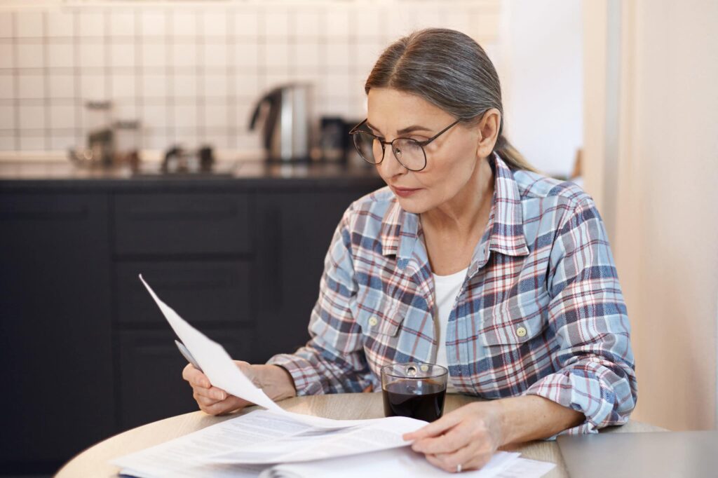 a woman sits to write a will at home part of advance care planning