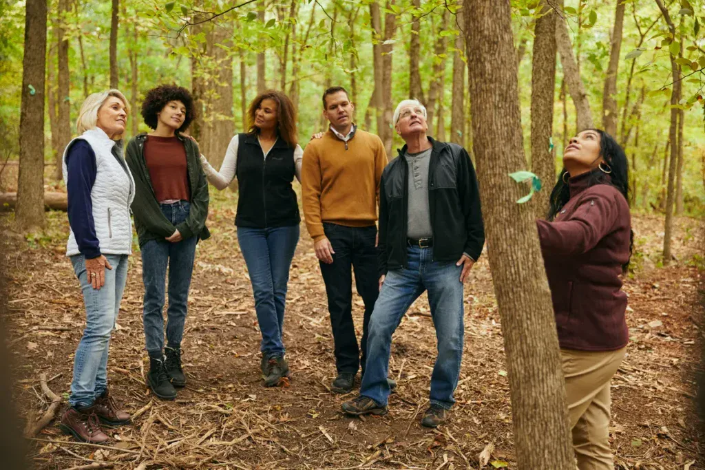 a family and forest guide look up at a memorial tree. The talk about end-of-life plans