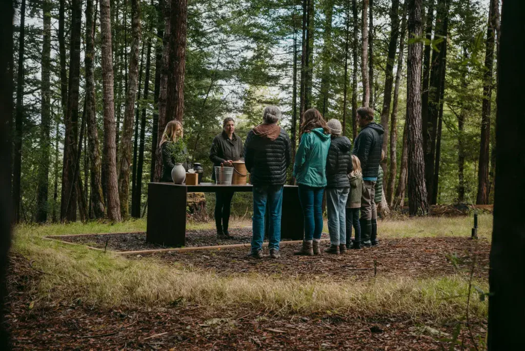 a family gathers at a memorial table in a forest. This is the difference of a memorial vs. celebration of life