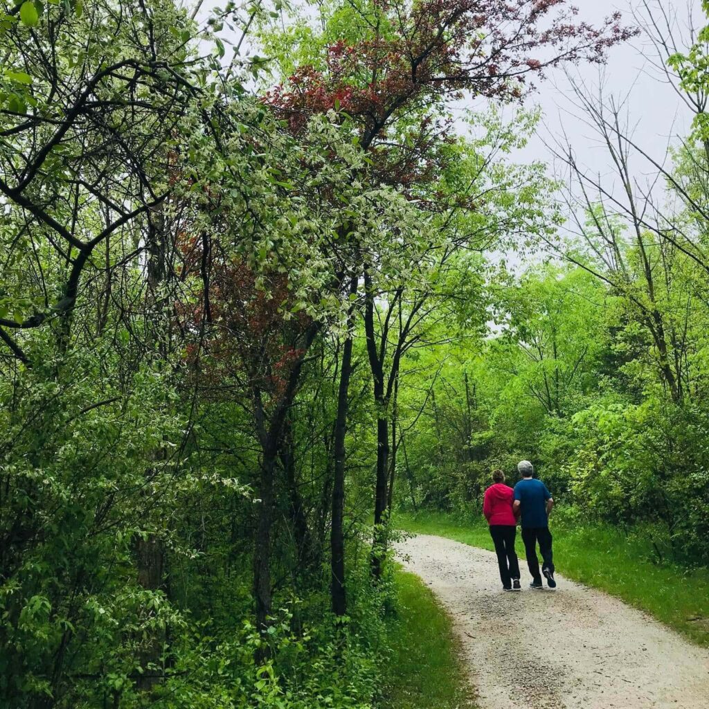 A couple walks along a trail in a memorial forest