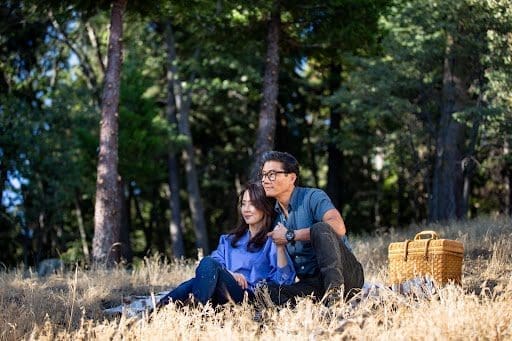 A senior couple sitting in a forest having a picnic