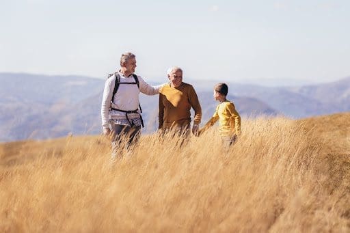 A family walks through an autumn field