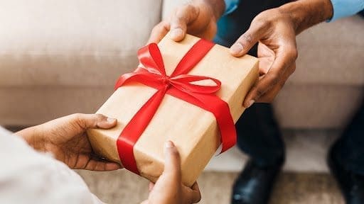 Women holding hands in front of a christmas tree