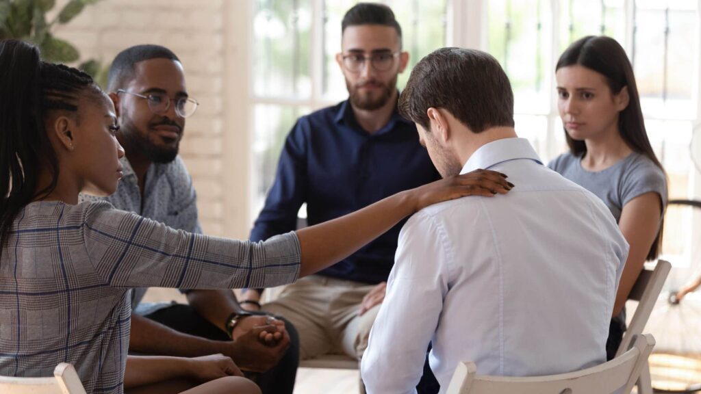 Grief support group meeting and comforting a member