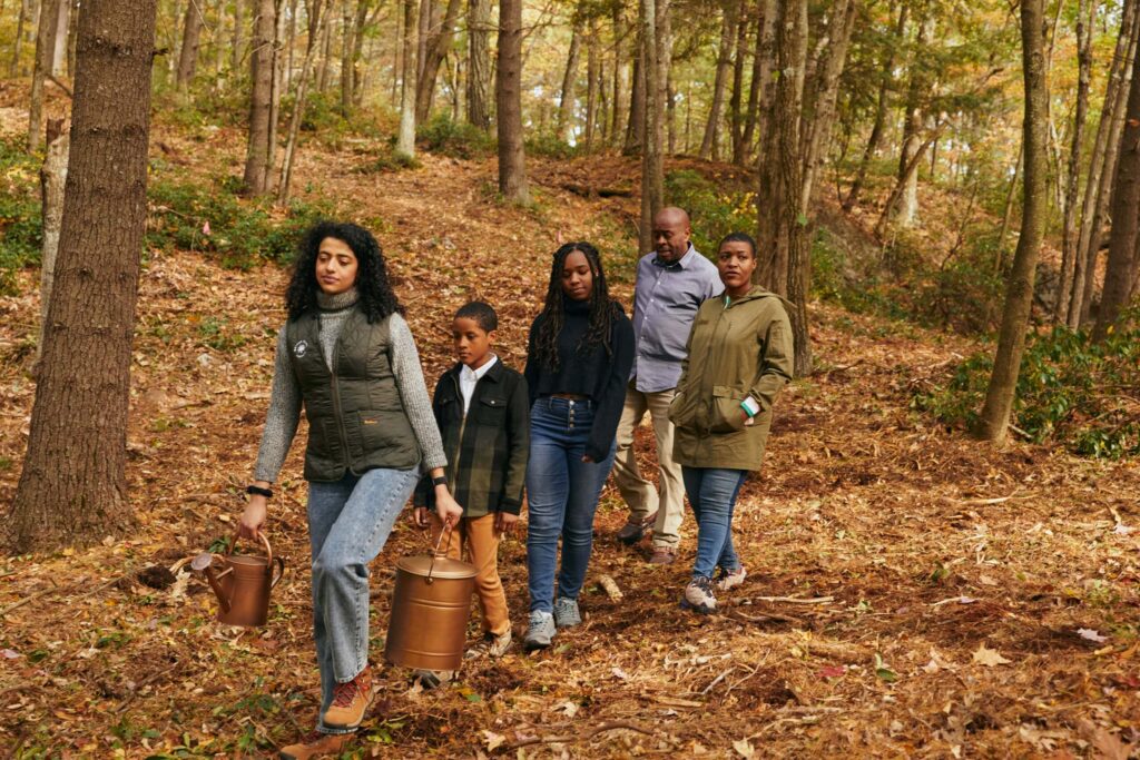 family walking in the forest with a guide to spread ashes. This is part of the checklist after the death of a parent
