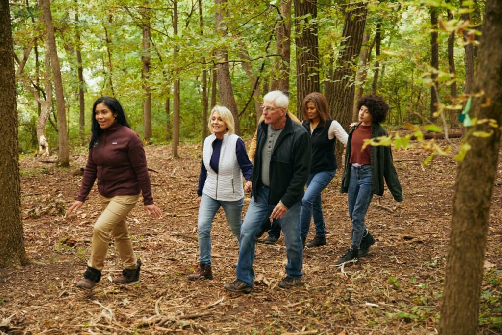 a family walks through the forest with a guide. They are tailking about taking care of aging parents