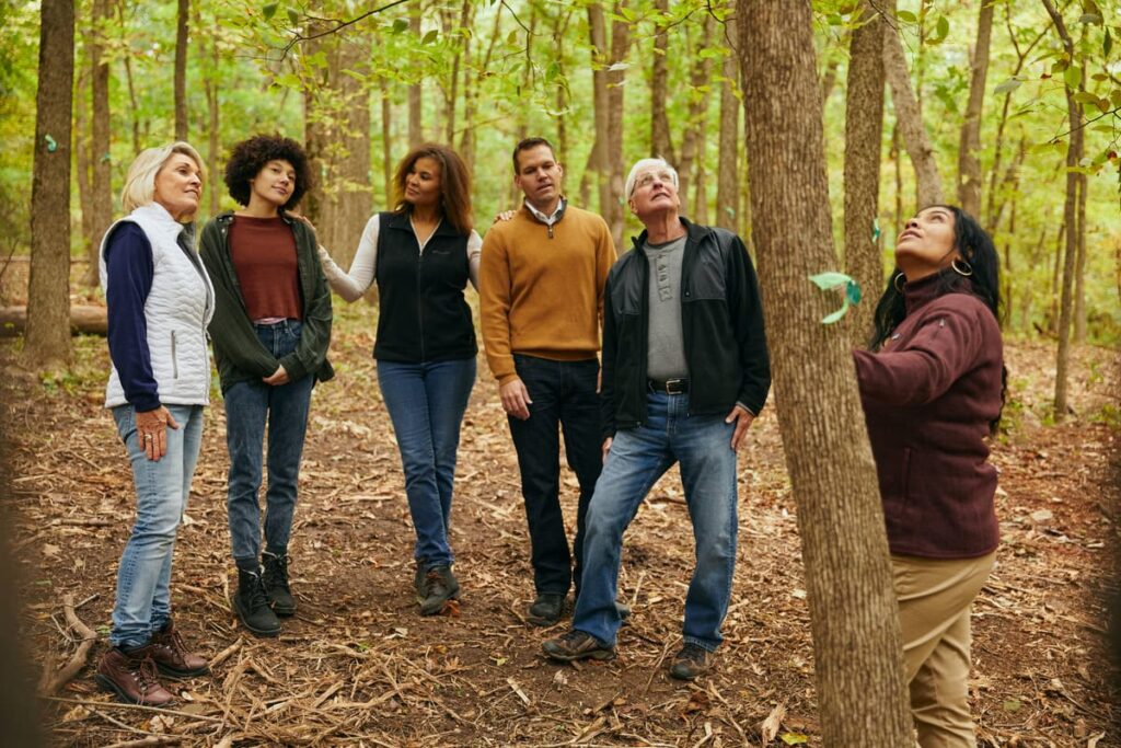 a family gathers at a tree with a guide. They are talking about taking care of aging parents