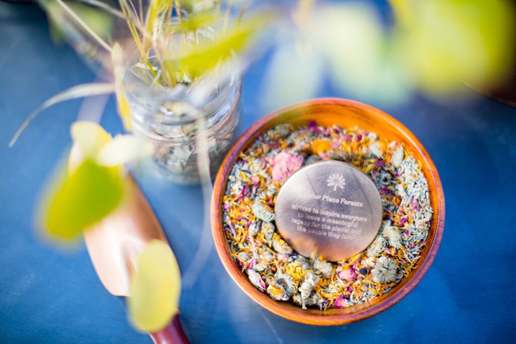 a memorial marker in a pot of dried flower petals. An example of an in loving memory template