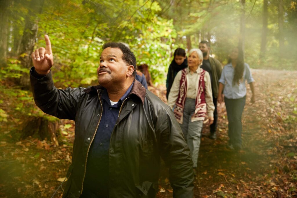a couple with a guide walk through the forest. They are talking about what is a columbarium