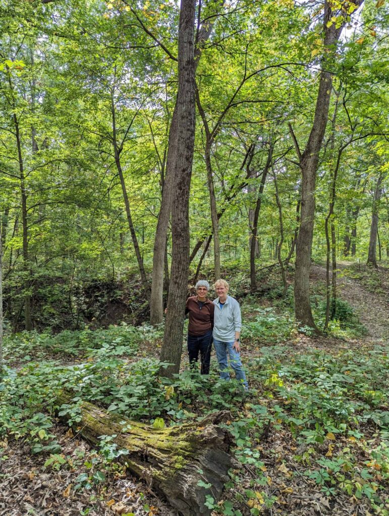 couple stand at their memorial tree giving back to the earth