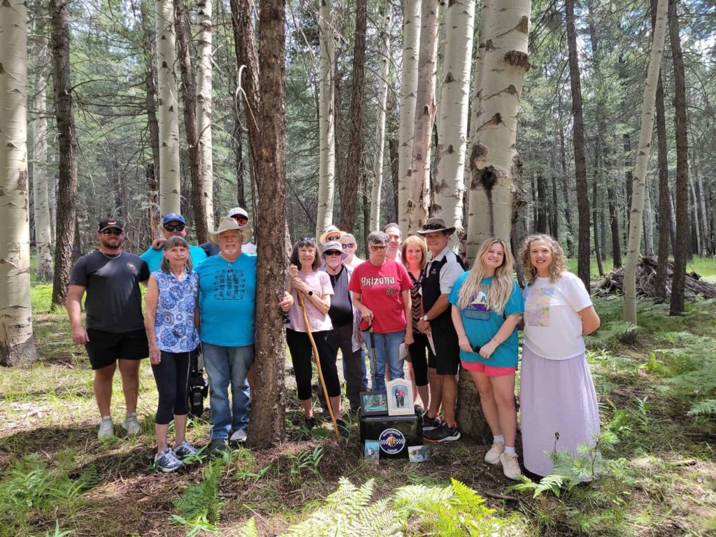 family at memorial tree to honor husband and father