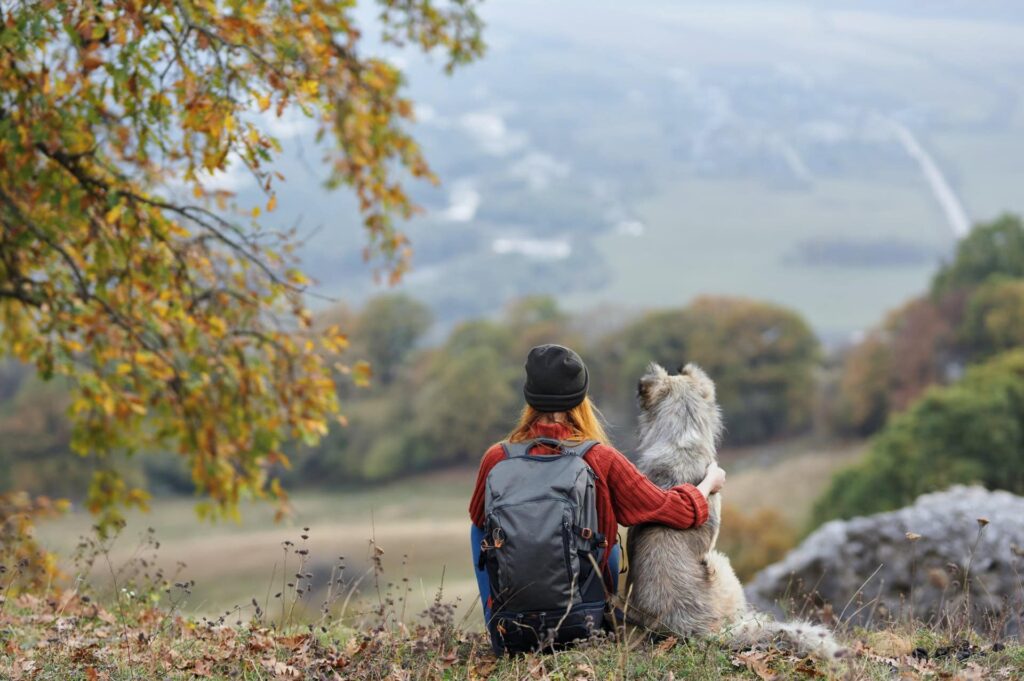 Woman with dog overlooking valley