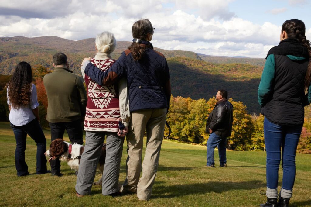 a group of mourners stands still in a moment of silence