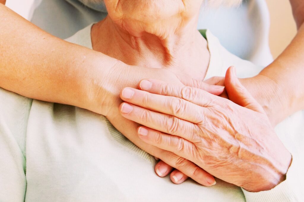 hands loving clasp an elderly hospice patient