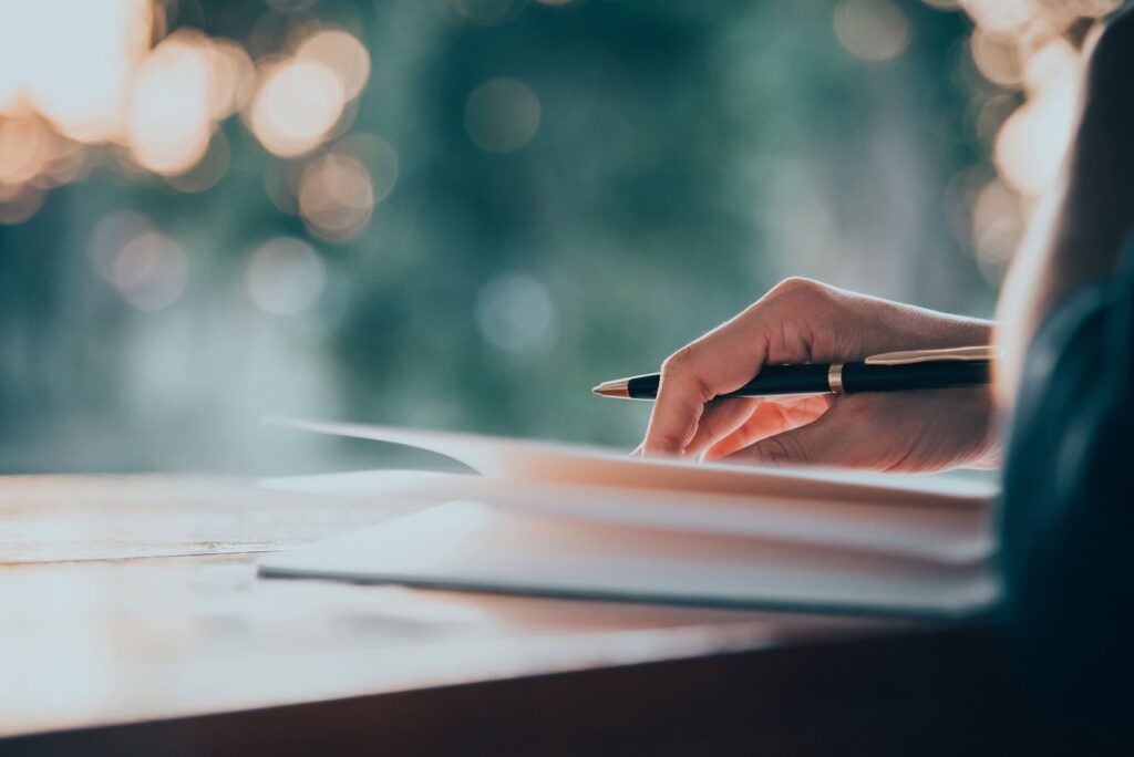 Close up of women's hand writing in a notebook