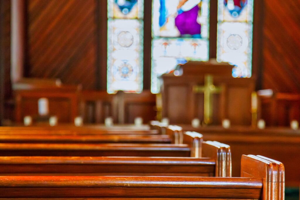 Stained glass windows in a church with wood pews