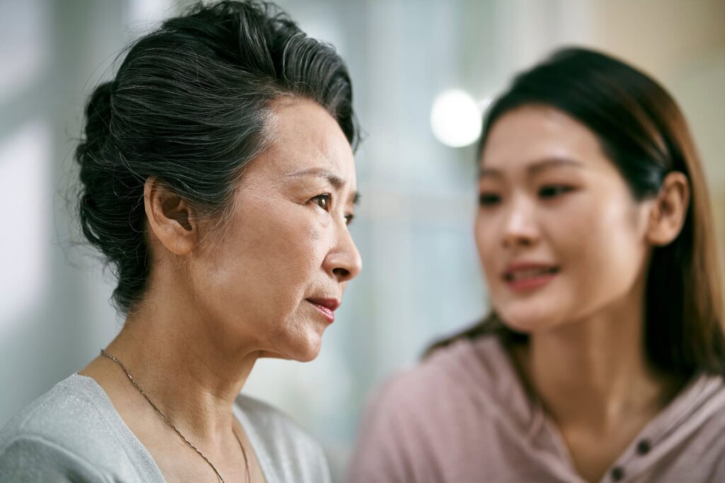 Young asian daughter comforting elderly mother