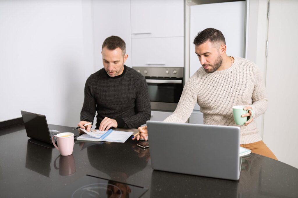 couple sitting at computer writing Obituary
