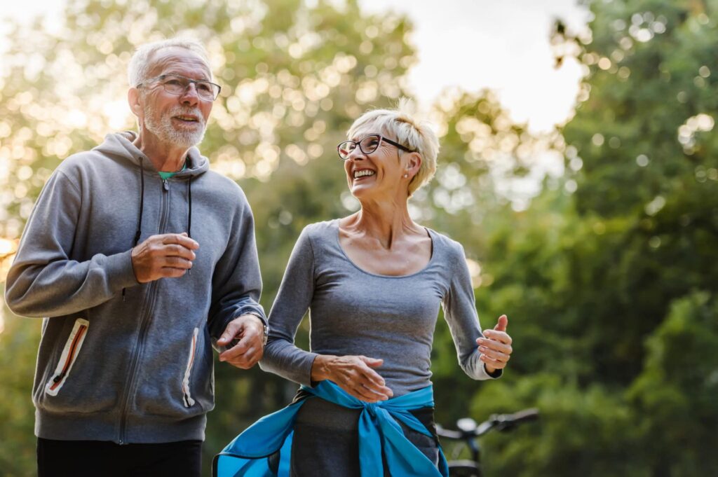Older Couple exercising in park 