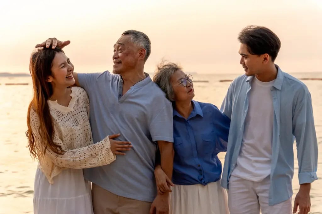 A multi-generational family enjoying a sunset on the beach.